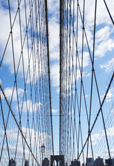 Fototapeta premium Unusual angle of view at famous Brooklyn Bridge on a sunny day with blue sky, NYC, USA. New York sightseeing and contemporary architecture lifestyle photo. Nobody. 