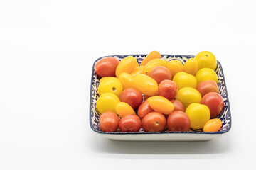 Cherry tomatoes of different colors in a font on a white background