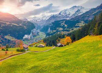 View from flying drone of Wengen village, district of Lauterbrunnen. Great sunrise scene of Swiss Alps. Astonishing autumn landscape of Switzerland countryside, Europe.