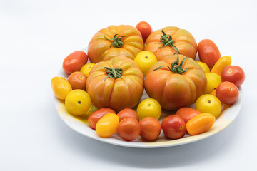 Different types of colorful tomatoes in a font on a white background
