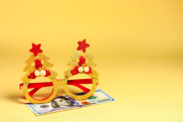 New Year's, Christmas masquerade glasses and money, dollars - lie on a yellow background. A hostile...