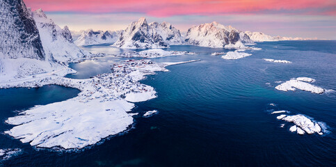 View from flying drone of Reine villege. Exciting sunset on popular tourist destination - Lofoten Island. Astonishing winter view of Norway, Europe. Breathtaking sescape of Norwegian sea.