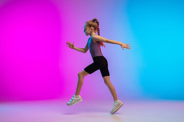 Fototapeta na wymiar Active. Teenage girl, professional runner, jogger in action, motion isolated on gradient pink-blue background in neon light. Concept of sport, movement, energy and dynamic, healthy lifestyle.