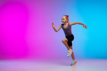 Healthy. Teenage girl, professional runner, jogger in action, motion isolated on gradient pink-blue...