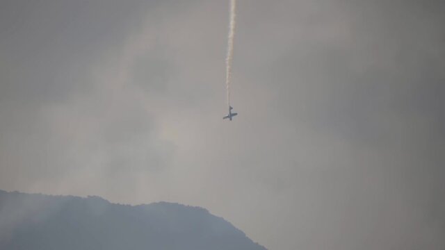 A small plane during an aerobatic simulation: plane engine failure, white smoke coming out from the engine as the plane crashes