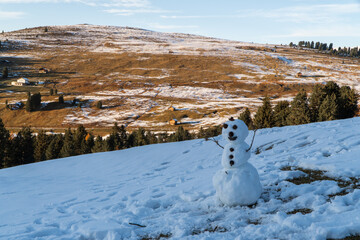 A snowman in the middle of the mountain. Concept of winter.