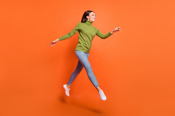 Fototapeta na wymiar Full body profile side photo of young excited girl run hurry jump sale look empty space isolated over orange color background