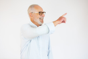 Fototapeta premium positive man pointing with hand and finger to the side. look here, happy old man showing direction, pension is being given here. this is the right way.