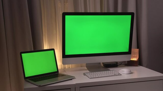 Green screen laptop computer sitting on a home work desk next to a desk lamp. Footage shot with RED, available in 4K and HD. Download the preview for free.