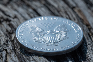 Eine glänzende Silbermünze / Unze (1 Oz American Silver Eagle) auf rustikalem Holz