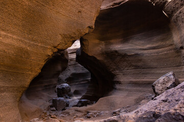 Empty rock canyon passage in Gran Canaria, Spain. Flowing shapes sandstone wall formation in Canary Islands. Eroded scenic landscape. Geology phenomenon concept