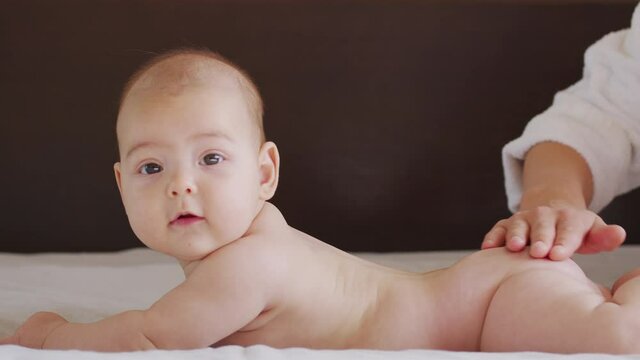 Mom Gives Back Massage To Her Little Child. Closeup.