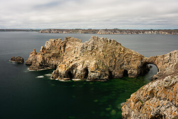 Sea arch at Pointe de Dinan on a cloudy day in summer