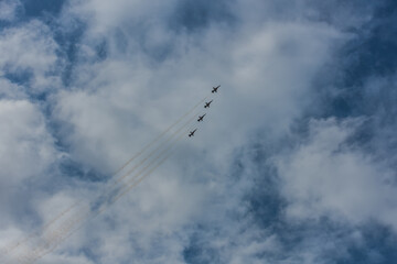 four fighter planes fly up steeply with beautiful sky