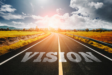 vision written on highway road in the middle of empty asphalt road and beautiful blue sky. Concept for vision future.
