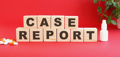 Fototapeta premium The words CASE REPORT is made of wooden cubes on a red background. Medical concept.