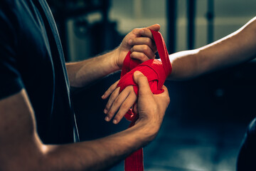 closeup of trainer puts bandages on woman hand