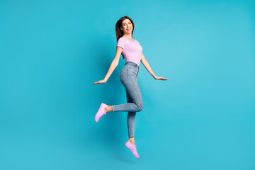 Fototapeta na wymiar Full length profile photo of lovely young girl jump wear pink t-shirt footwear jeans isolated blue color background