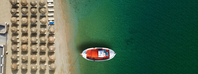 Aerial top view ultra wide photo of traditional wooden fishing boat near Aegean island destination port with turquoise sea, Greece