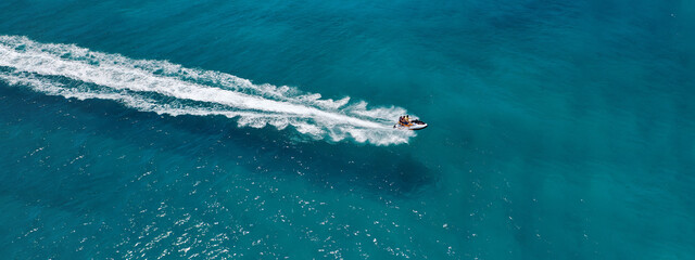 Aerial drone ultra wide photo of jet ski watercraft cruising in high speed in deep blue open ocean sea