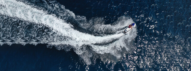 Aerial drone ultra wide photo of jet ski watercraft cruising in high speed in deep blue open ocean sea