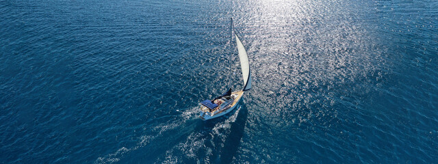 Aerial drone ultra wide photo of beautiful sailboat sailing in tropical exotic bay with emerald...