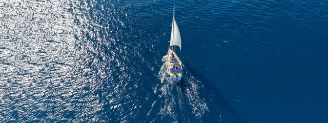 Aerial drone ultra wide photo of beautiful sailboat sailing in tropical exotic bay with emerald clear sea