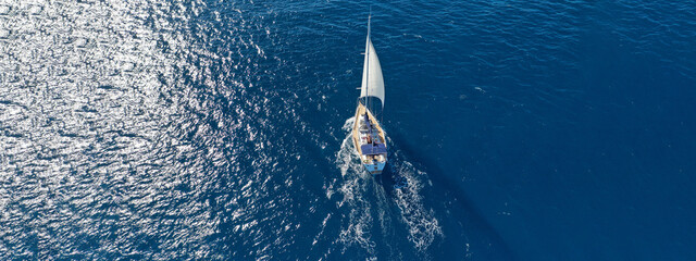 Aerial drone ultra wide photo of beautiful sailboat sailing in tropical exotic bay with emerald...