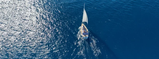 Deurstickers Aerial drone ultra wide photo of beautiful sailboat sailing in tropical exotic bay with emerald clear sea © aerial-drone