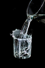 Glass with water on a black background. Photo taken with selective focus and noise effect