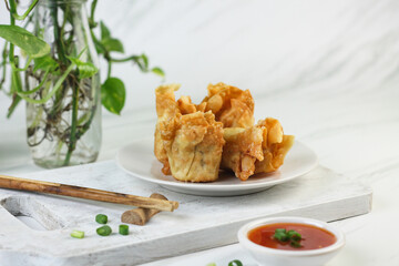 Siomay or Siomay Goreng, Indonesian popular street food, made from fish, shrimp wrapped with dumpling wrapper, steamed and deep fried, served with spicy tomato sauce or peanut sauce. Selective focus. 