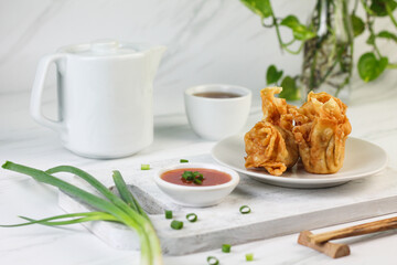 Siomay or Siomay Goreng, Indonesian popular street food, made from fish, shrimp wrapped with dumpling wrapper, steamed and deep fried, served with spicy tomato sauce or peanut sauce. Selective focus. 