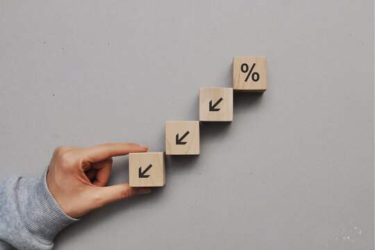 The "percentages" sign on the wooden cubes is a down arrow. Decrease in revenue and profit