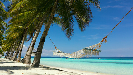 Beautiful tropical island with sand beach and hammock. Panglao, Philippines. Seascape with beautiful beach and palm trees.