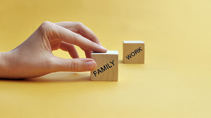 Wooden blocks with the inscription: Family and work. Choose between family and work. Family...