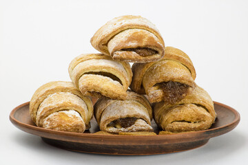 Appetizing sweet croissants on a clay plate on a white background
