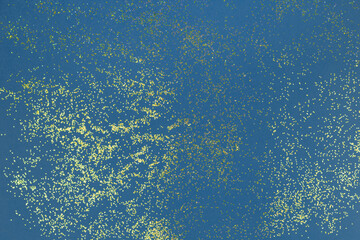 A splash of Golden sparks on a blue. Confetti background. Sparkling texture. Festive backdrop for your projects