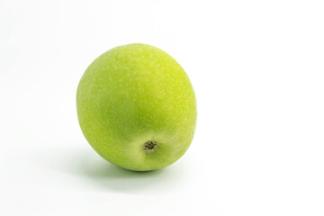 A ripe green apple lies on a white background close-up