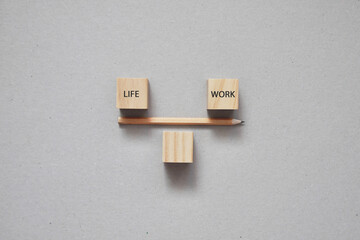 Wooden cubes in the form of scales with the inscription: life and work. The balance between work...