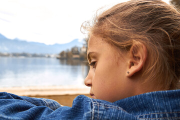Little lonely girl in anxious emotion outdoors.