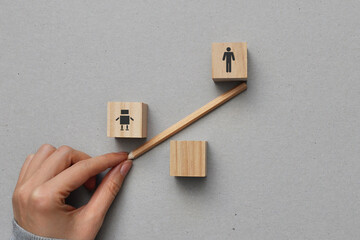 Symbolic image of scales made of wooden cubes with a drawing of a robot and a human. The advantage...