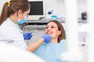 Young woman having teeth examined by female dentist in dental office.