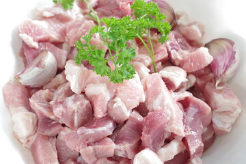 raw bacon with parsley on white plate