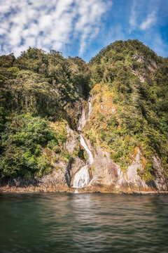 A pure water spring on a cliff in the wilderness of Doubtful Sound Fjord with clean water that it becomes known as ' the water of life' in Fiordland National Park, New Zealand, South Island.