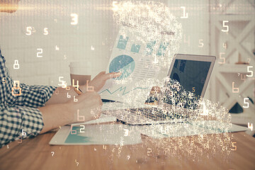 Technology theme hologram with man working on computer on background. High tech concept. Double exposure.