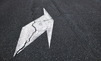Fototapeta premium Arrow sign turn on rough black asphalt track