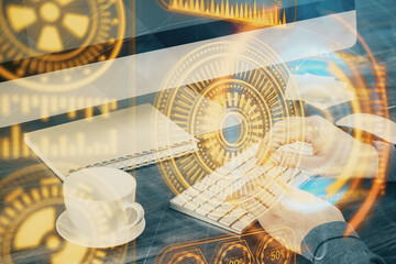 Technology theme hologram with man working on computer on background. High tech concept. Multi exposure.