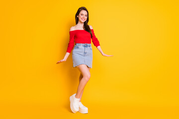 Fototapeta na wymiar Full length photo of cute charming girlish young lady beaming smile posing prom celebration dream girl wear shirt uncovered shoulders denim mini skirt isolated vivid yellow color background