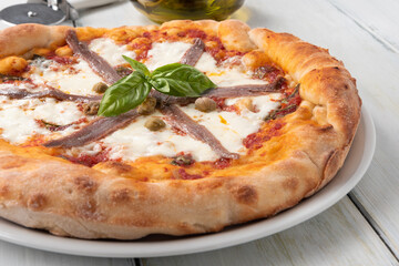 Deliziosa pizza con mozzarella, sugo, capperi e alici
