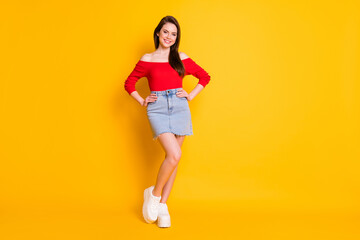 Full length body size view of her she nice attractive lovable gorgeous content cheerful girl posing hands on hips isolated over bright vivid shine vibrant yellow color background